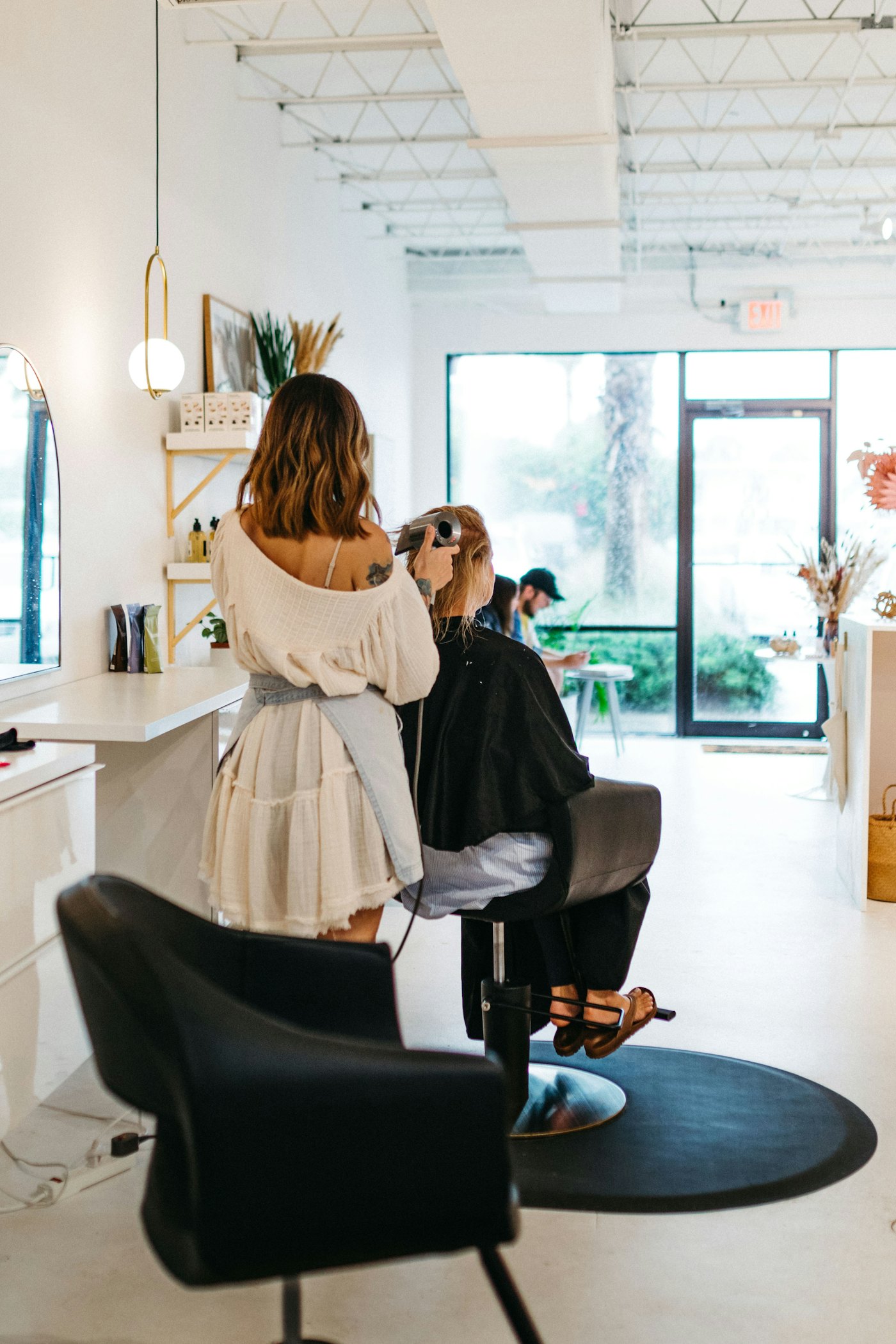 AI receptionist for salons answering client booking messages while a stylist works