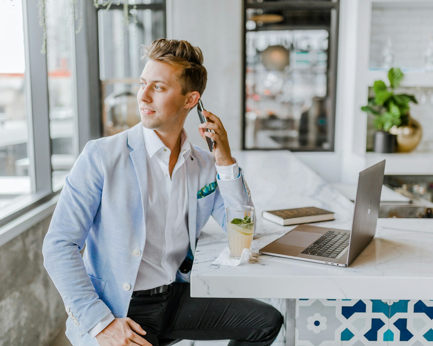 Small business owner using a cheap answering service for small business on his phone and laptop