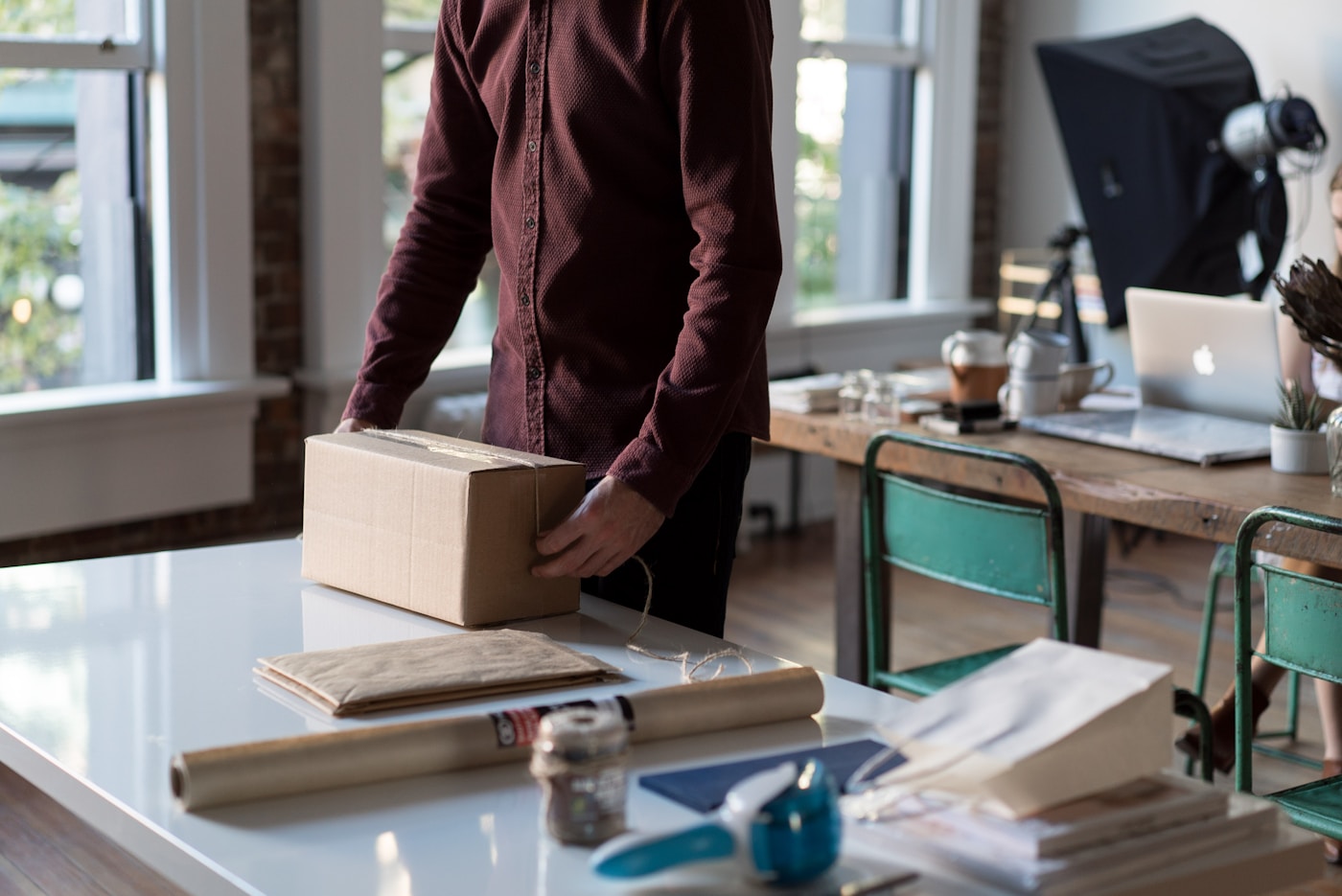 Online store owner packing an order, using ecommerce customer service outsourcing to answer shipping questions