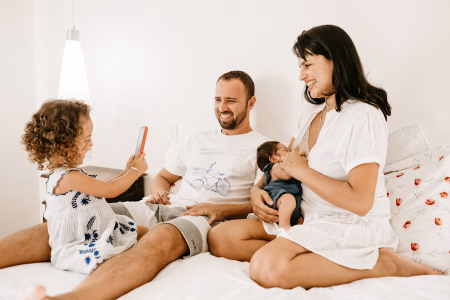 Family relaxing together on a bed in the evening