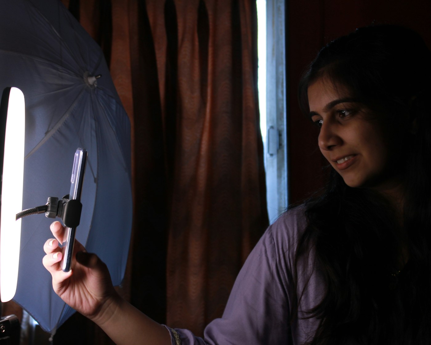 Content creator filming with a ring light, backed by a virtual assistant for content creators