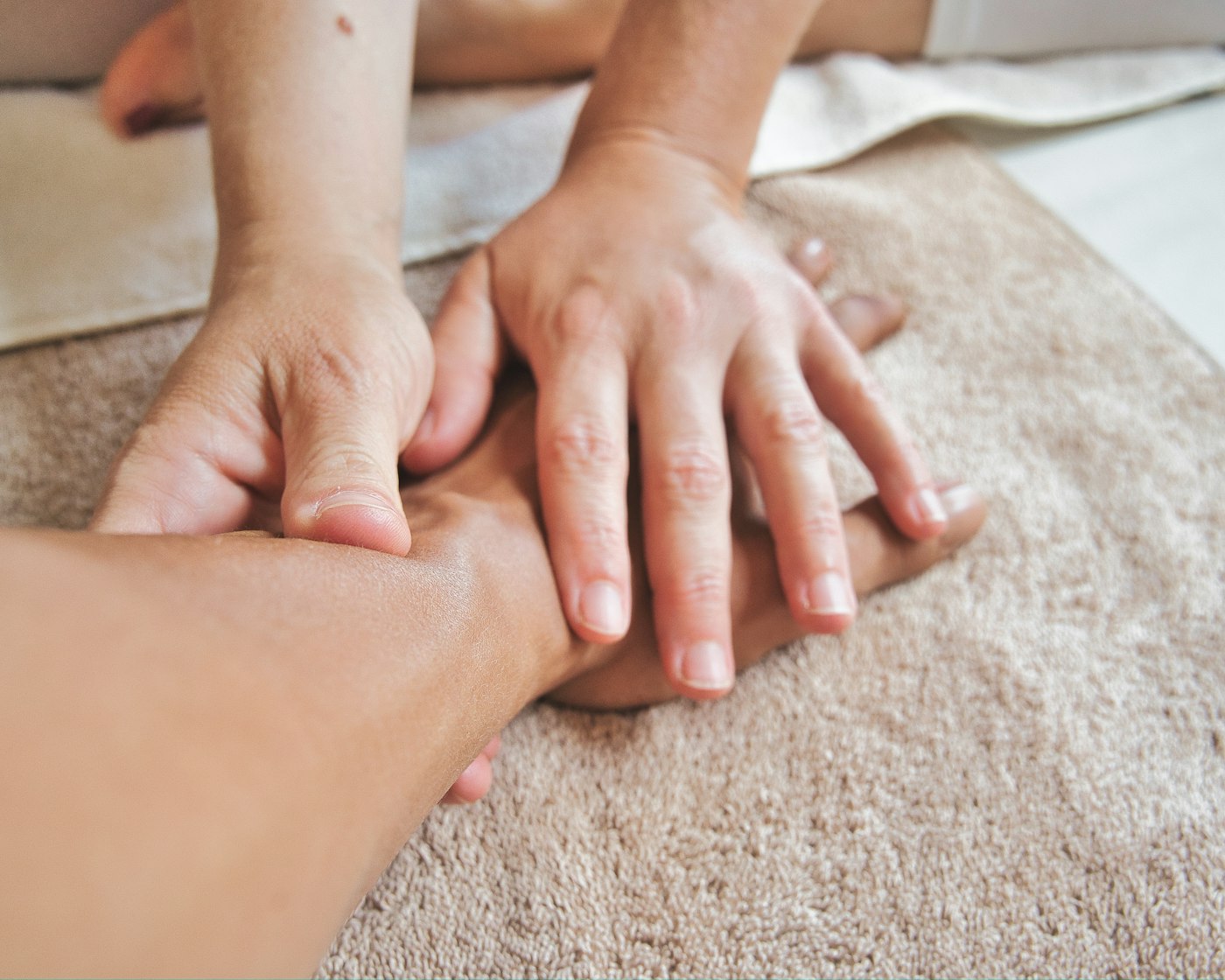 Massage therapist working with a client's hand, virtual assistant for massage therapists