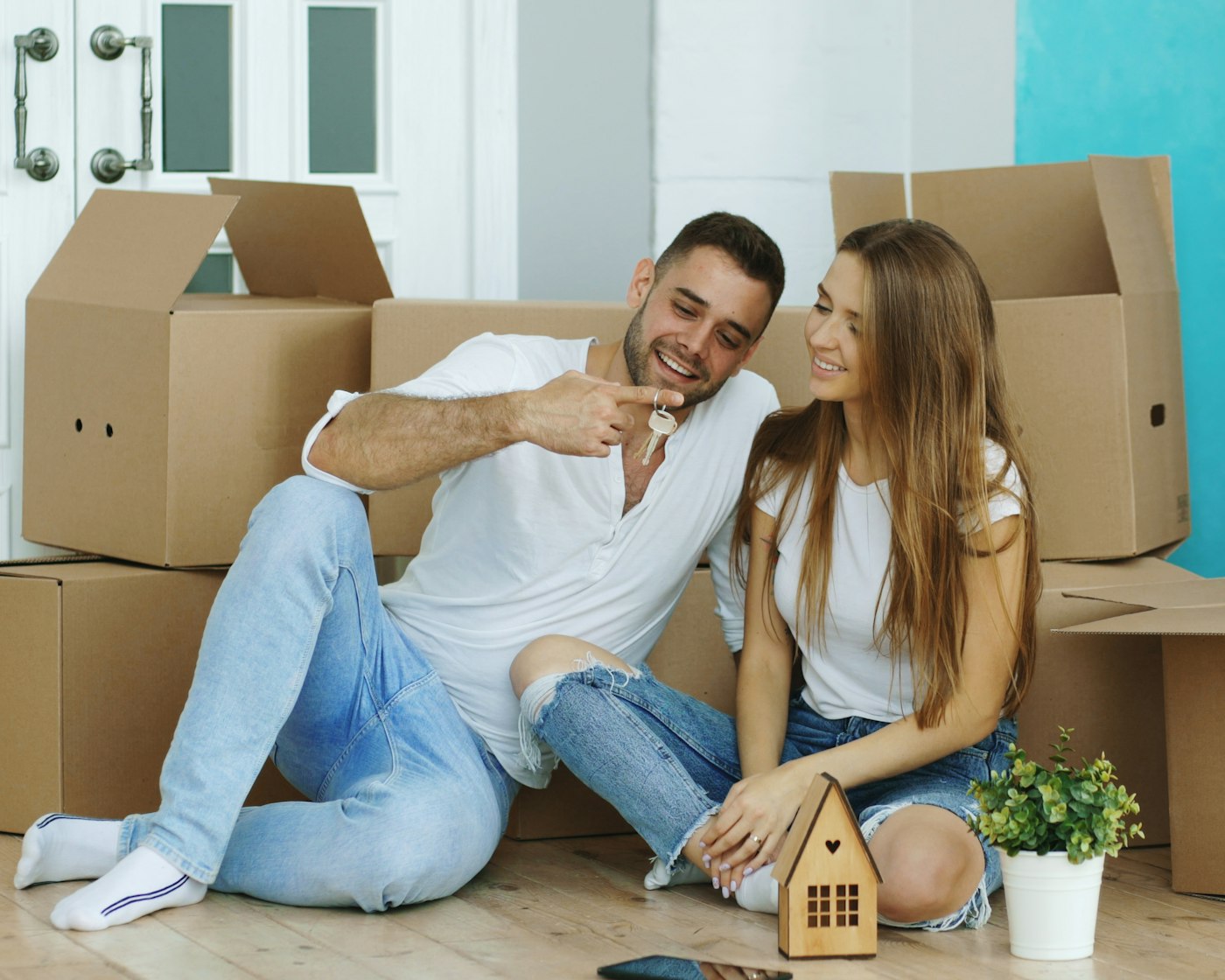 Couple holding new house keys, the kind of status update a virtual assistant for mortgage brokers sends during a loan