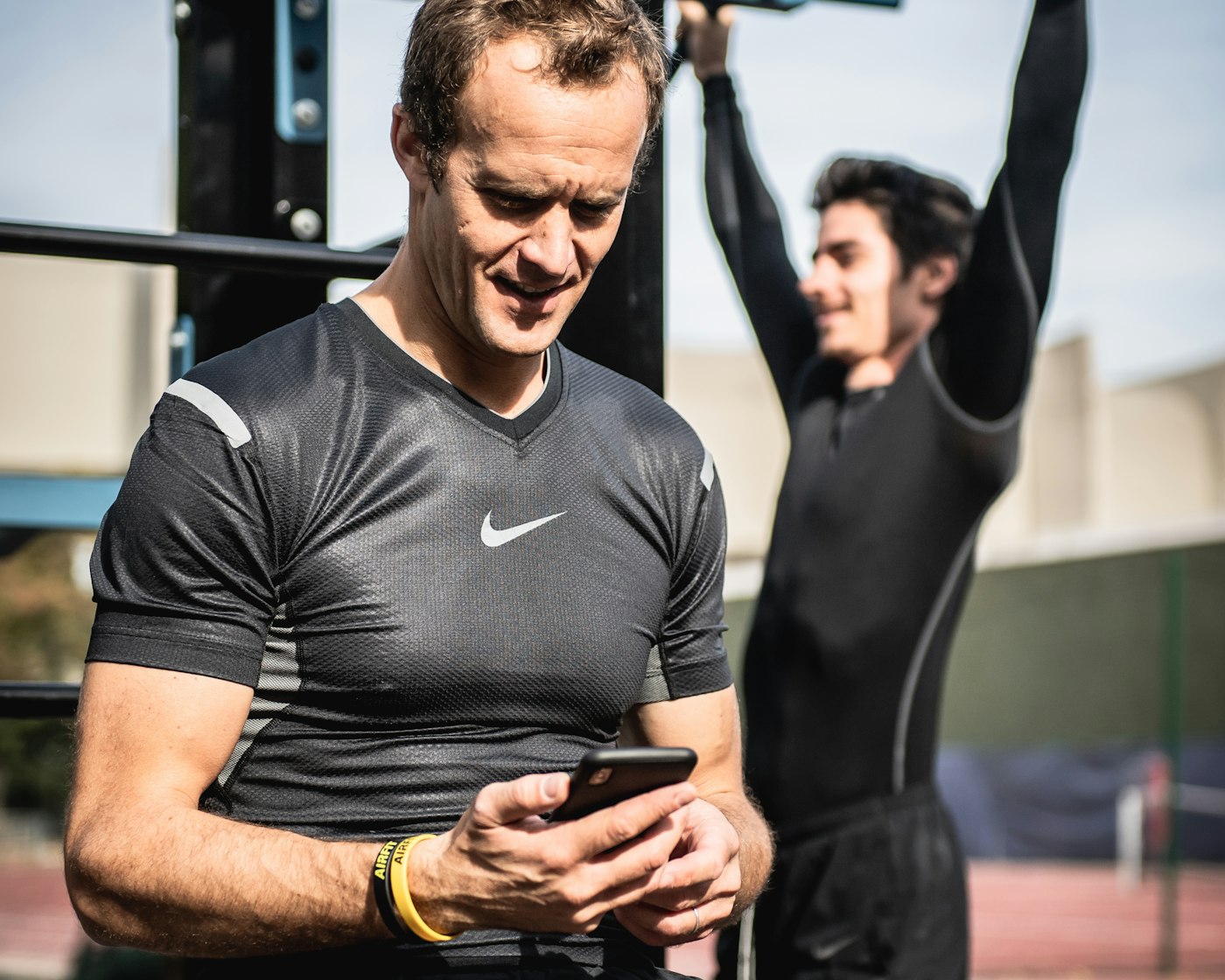 Personal trainer checking phone at the gym, virtual assistant for personal trainers