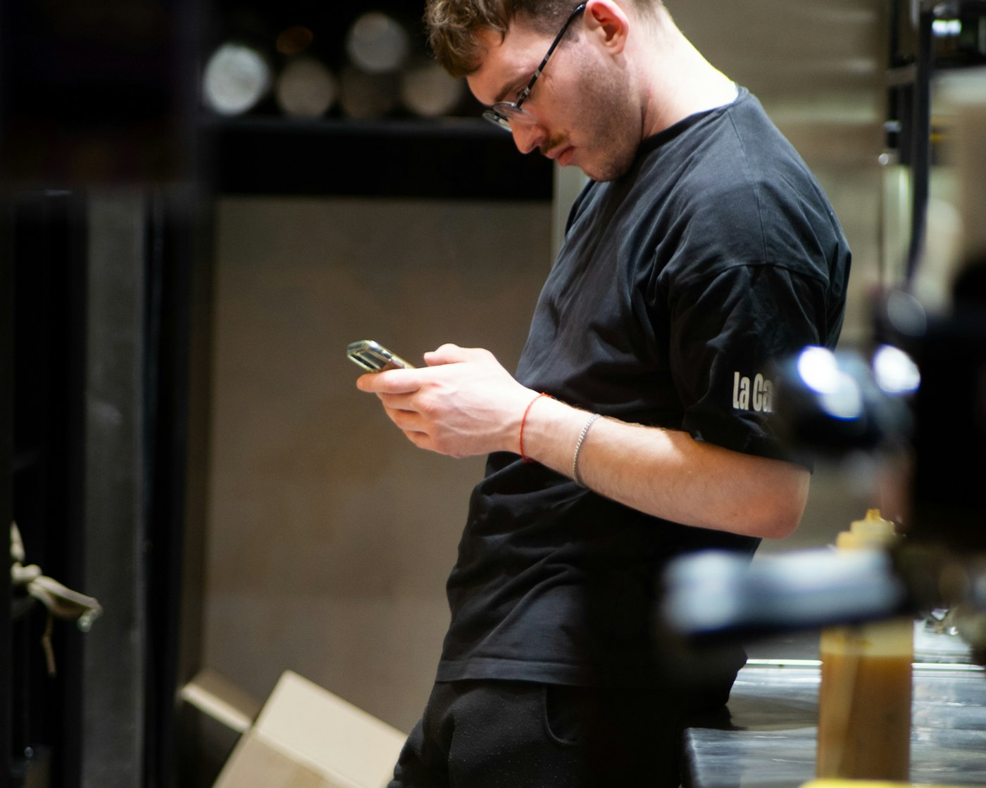 Restaurant staffer checking phone during service, helped by a virtual assistant for restaurants